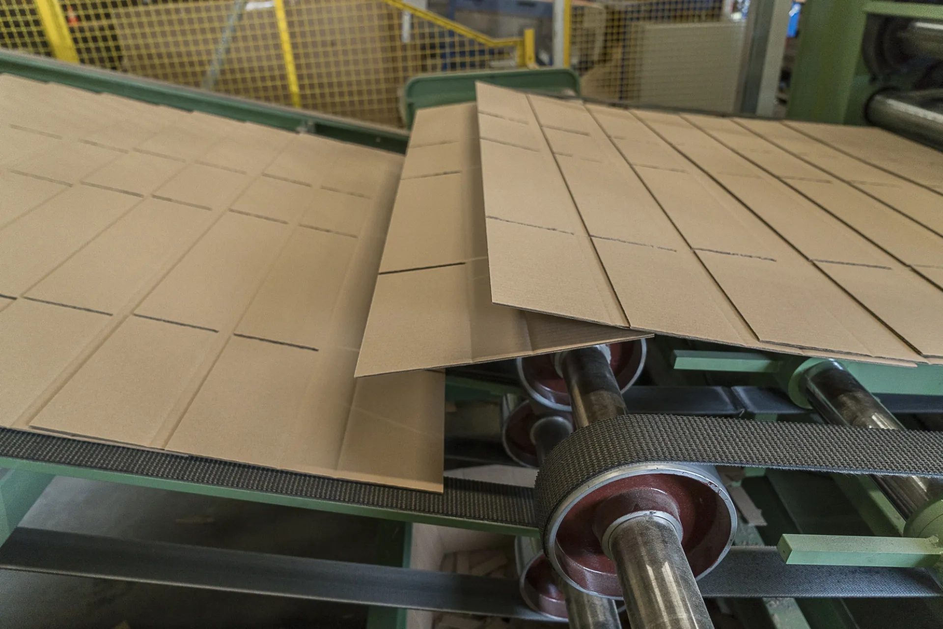 Kartonplatten werden in der Produktionsanlage präzise zugeschnitten und gefaltet | Kartonsaufmass.de